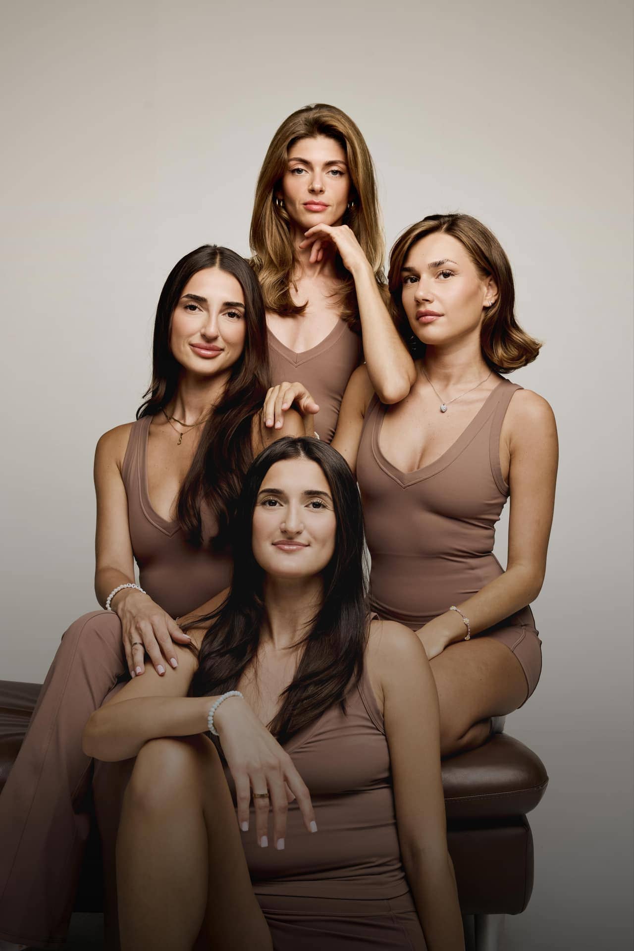 Vier Frauen in ruhiger, eleganter Pose, warmer Beige-Look